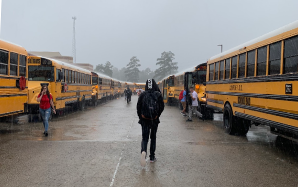 A student walks to their bus after being released five minutes early due to heavy rainfall.