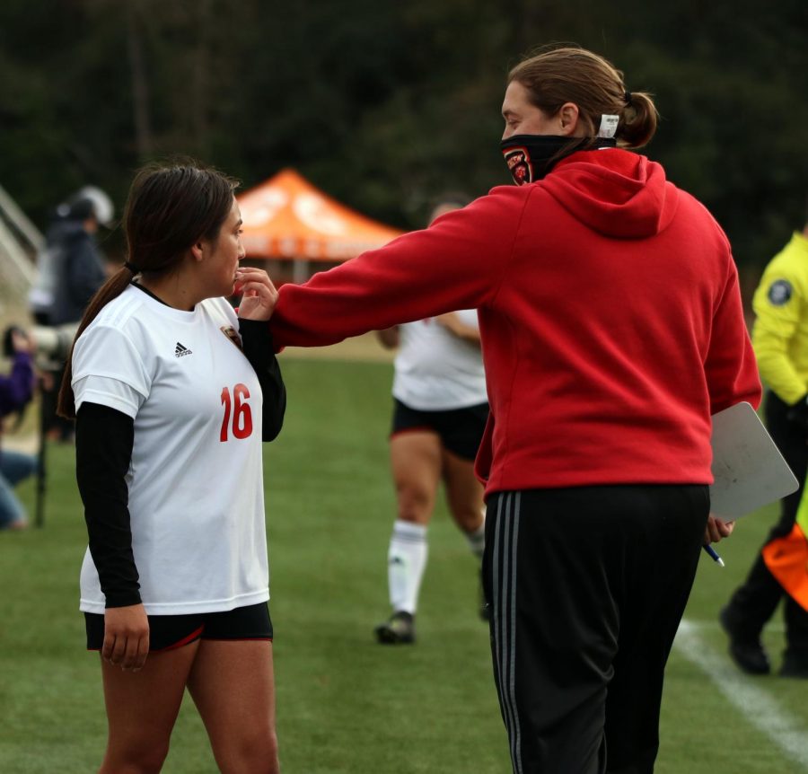 After the first half finished, Coach Kloes pats Sophomore Berenice Lopez on the shoulder and tells her she did a good job at The Woodlands Tournament on January 7, 2021.