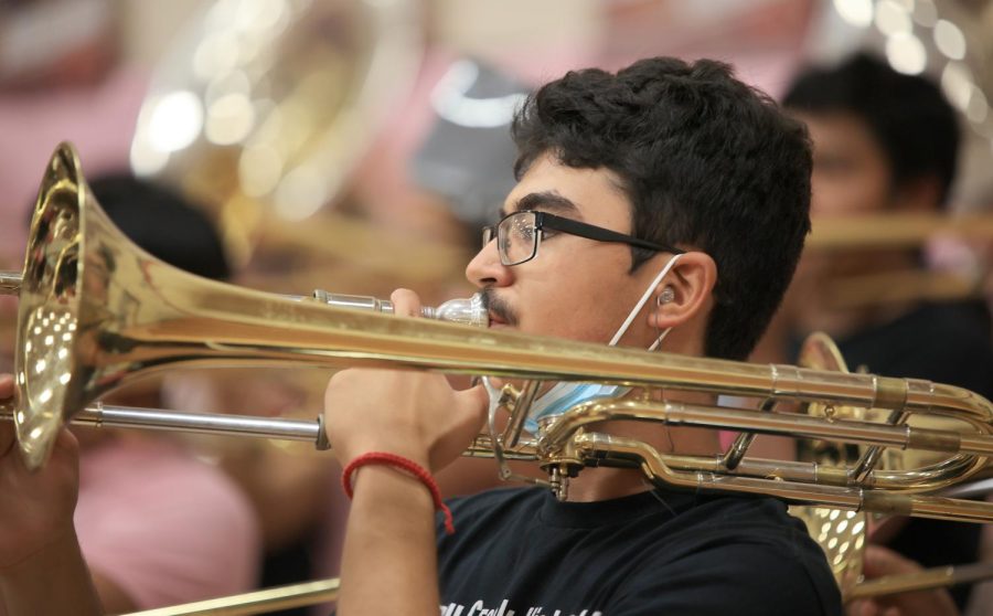 Junior Humberto Sanez performs in front of the school with the rest of the band during the pink out pep rally on Oct. 14, 2022. 