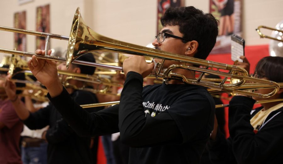 MAKE NOISE. Junior Humberto Saenz plays the trombone during the pep rally at Caney Creek High School on Oct 28, 2022. Humberto feels confident and happy playing. “One of the reasons I didnt drift away from playing the trombone was because the instrument was just fun to play with its loud, full tone.” Humberto said.