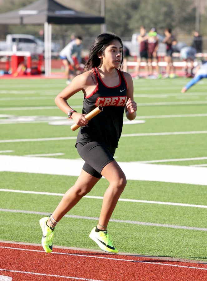 PASS IT ON. Freshman Andrea Rangel running the first line in the girls 4x1600 on Thursday, Feb. 9, 2023, Varsity Track competed against many other schools at the Lake Houston relays at Huffman.