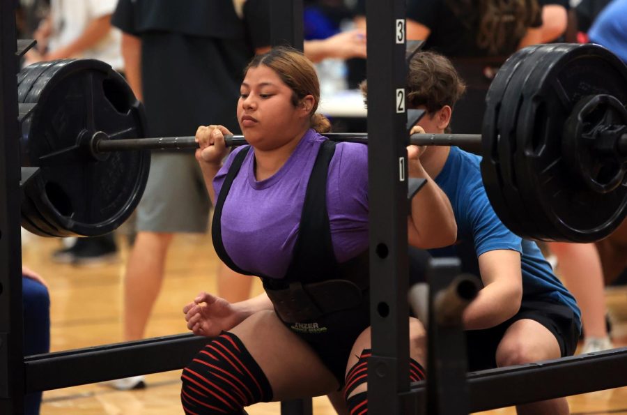 FOCUSED. Senior Bridgette Miranda is on her first attempt after squatting her first weights at the Alvin High School powerlifting regional meet on Feb. 25, 2023. Miranda was able to successfully squat 355 pounds on her second attempt. “It was such a scary feeling because that was my max I was hitting,” Miranda said.
