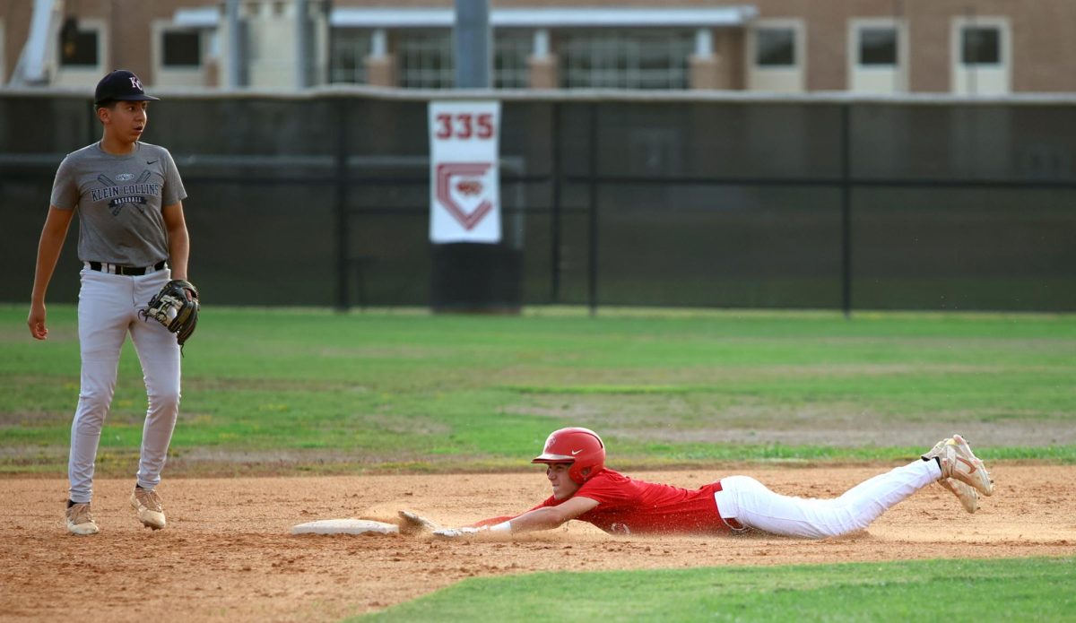 ONE STEP CLOSER. Junior Derek Darkenwald throws himself onto second base to avoid getting out on Sept. 6, 2023 at Caney Creek High School. Throwing himself, allowed Darkenwald to get closer to scoring.