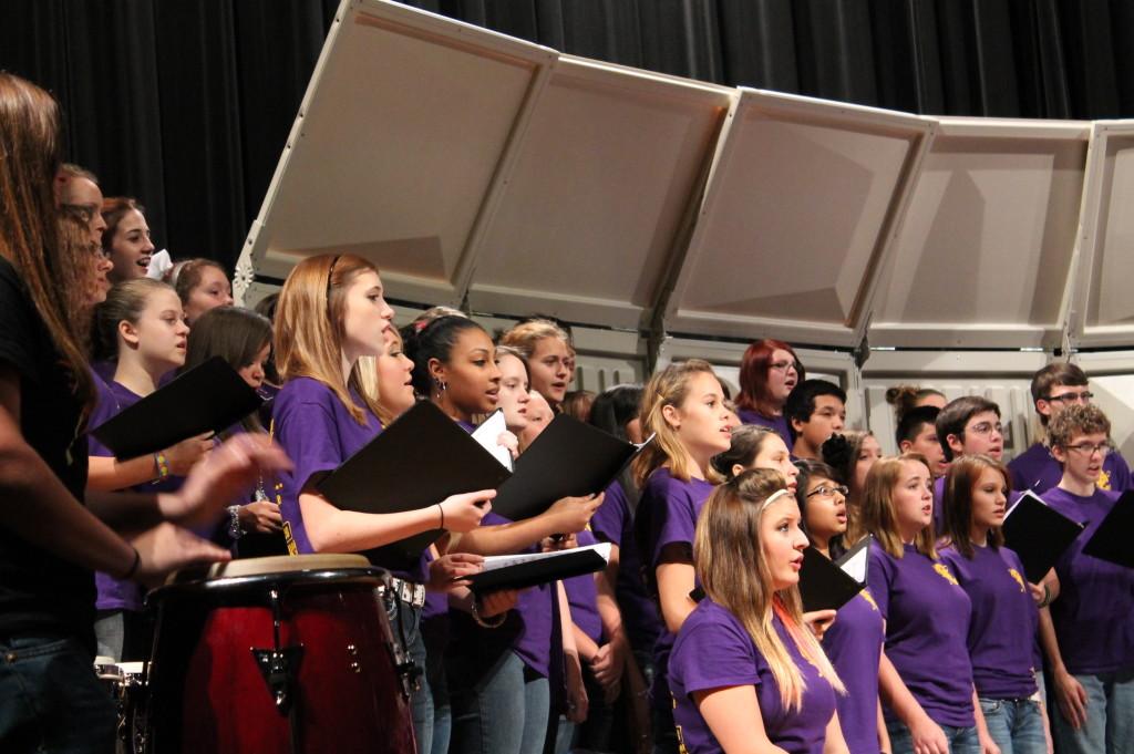 Choir sings their song along with a traditional drum. 