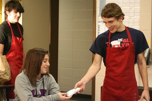 A Food Tech Student delivers a breakfast taco on Taco Wednesday 