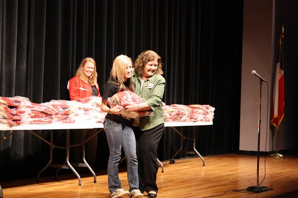 Principle Trish McClure presents a Letterman to a deserving student in the auditorium. 