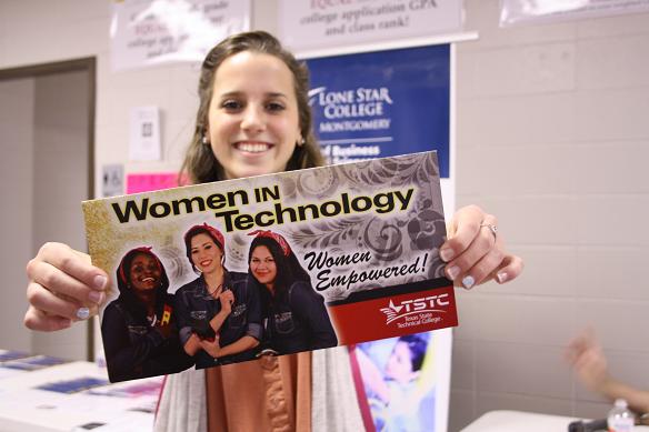 A student holds up the Lone Star Women in Technology poster in the College and Career Center