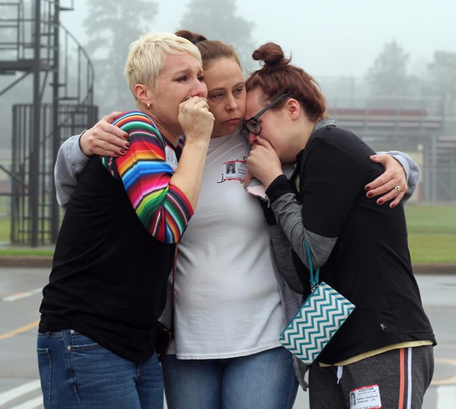 Shanna Thomas embraces Tiffany Burton and Kaitlyn Danford as they watch the students they love simulate a fatality wreck as part of the Shattered Lives program Wednesday, Feb. 27, 2019, at Caney Creek High School. Burton’s daughter Kameron, a junior, was a victim in the simulation. 