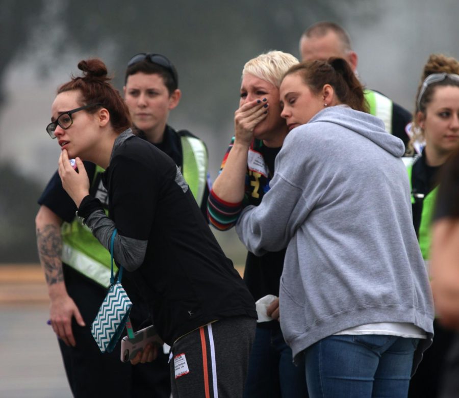 Kaitlyn Danford, left, looks onto the simulated, Shattered Lives wreck in grief, as do Tiffany Burton and Shanna Thomas, right, who all knew students participating in the program Wednesday, Feb. 27, 2019, at Caney Creek High School.