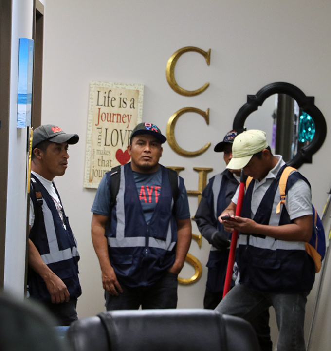 Contractors meet before ripping out carpet in the councilors office.