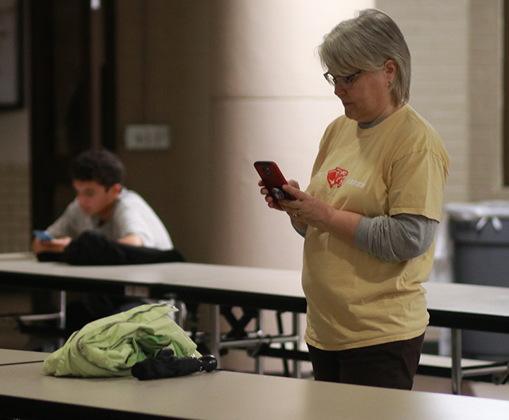 Special Education Department Chair Eden Young texts family members while waiting on the weather to die down.