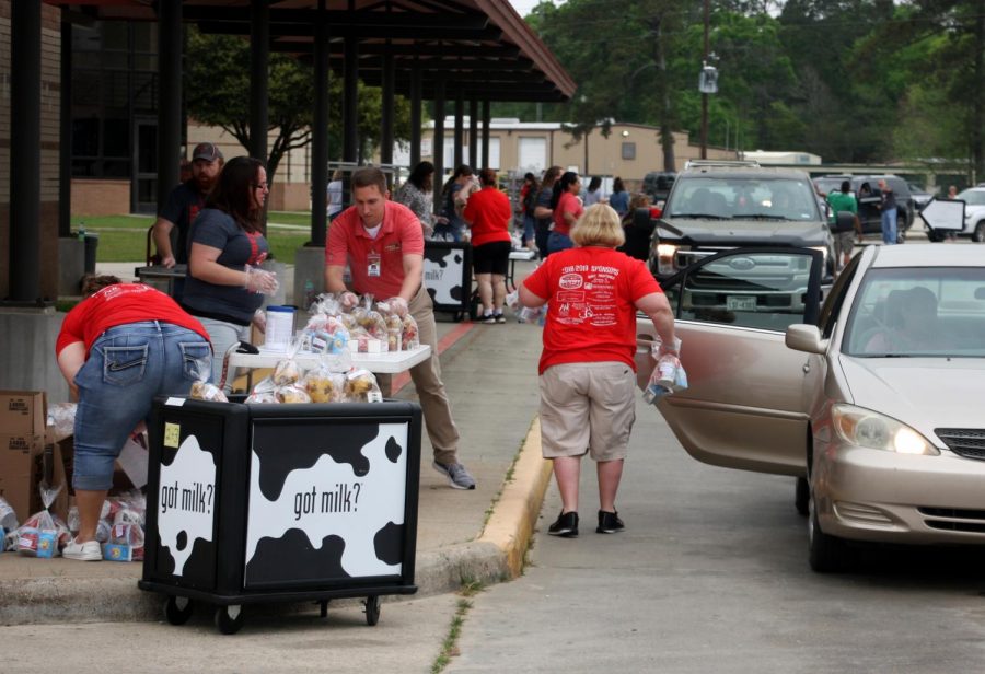Staff members from the Caney Creek feeder zone in the middle of the rush  staff handing out food.