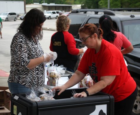 Caney Creek feeder zone employees unload breakfast and lunch bags during a curbside food distribution March 20,  soon after the district stopped in-person learning.