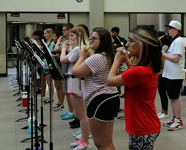 Band students practice in the cafeteria without masks before school starts on July 28 due to the construction occurring in the school’s parking lot and with less restrictions with Covid-19. Freshmen Addy Blanks said “We had to wear a face shield while playing, and every time we had to go over rhythms we had to have a facemask.”