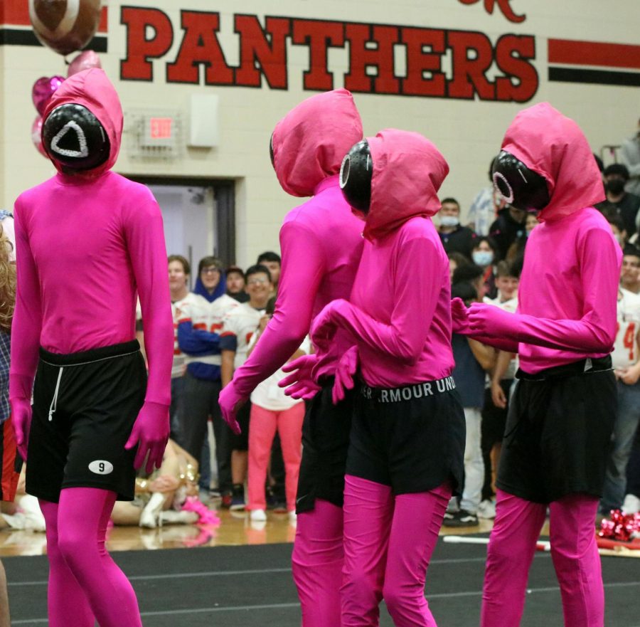 Kids dress up as squid game characters for pink out pep rally.