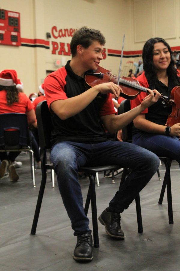 Jostin Segura is practicing with his violin before the orchestra concert begins