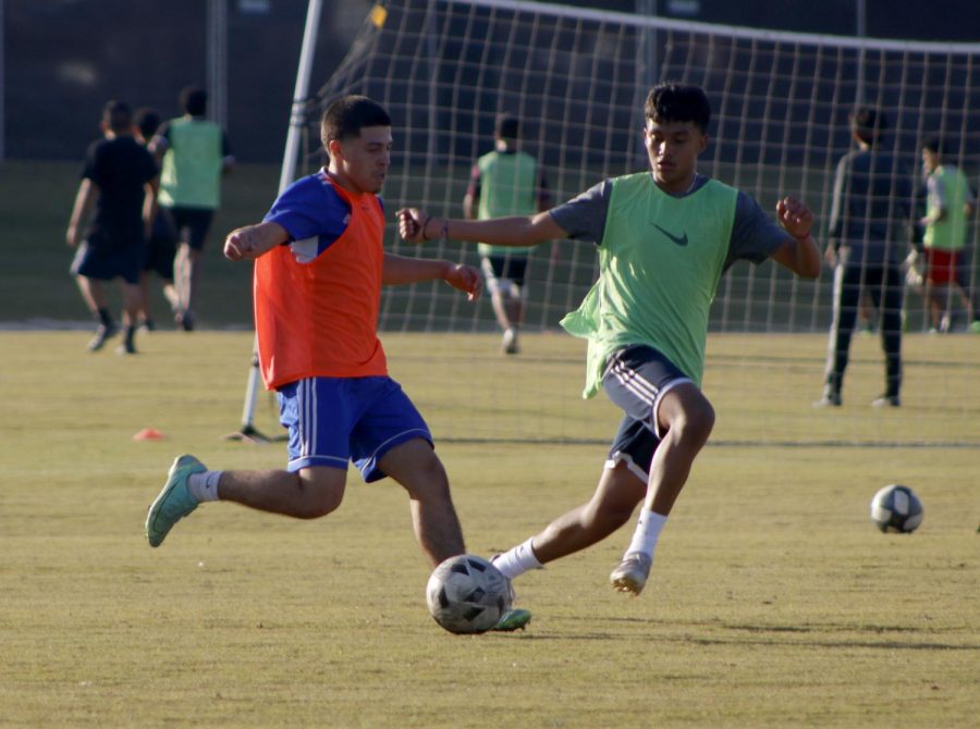 Junior Fernando Gomez  kicking the ball towards other teammate during tryouts.