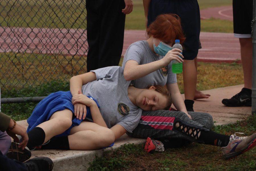 TIME TO RELAX: Isabella Rezzoffi (10) and Rachel Attaway (11) relaxing while the drill teams practiced.