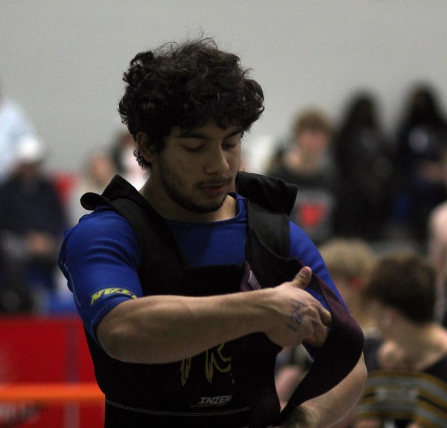 Junior Jeremy Soto prepares for his bench by wrapping his hands.The wrist wraps help keep the bar stable, Jeremy got all three attempts for his bench. 