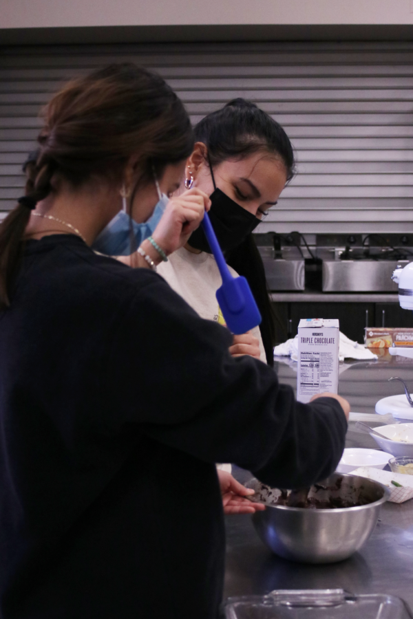 EVERYTHING IS FUN WITH FOOD: Lucero Zambrano (10) and Nancy Hernandez (11) having fun while giving the brownie  mix one last mix.