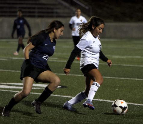 Berenice Lopez [12] dribbles the ball away from New Caney defender on Tuesday night. 