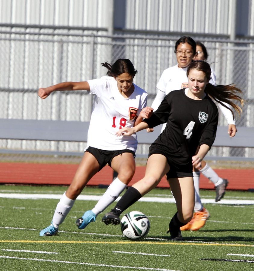 Emily Jimenez (11) fights Kingwood  Park player  for the ball.