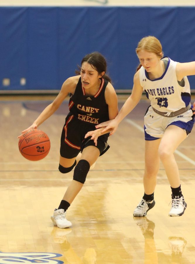 Varsity player Emily Garcia dribbles against opponent.