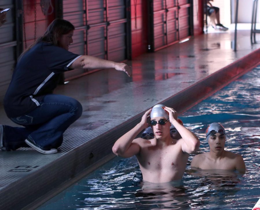 Junior Matt Danis being instructed by his coach at a swim meet at Aldine.