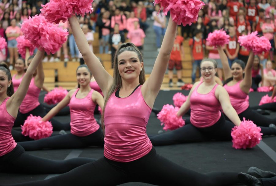 SPLITTIN PRETTY. Senior Cloie Peters and the dance team all drop into the splits while performing in the gym for the pink out pep rally on October 14, 2022. I get nervous but I build up my confidence up to show what we worked hard for, Peters said. I honestly think being nervous makes me perform better.