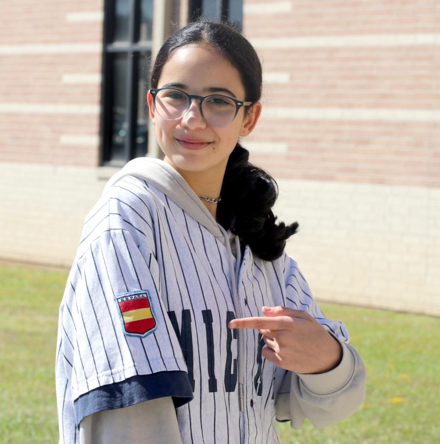 IT’S DIFFERENT BUT NICE. Sophmore Lidia Linde Figuero poses with her shirt her father gave her outside Caney Creek for a picture on Oct. 19, 2022. Figueros mom had stitched patches on the shirt of a Puerto Rico and Spanish flag due to the fact that she’s both ethnics. Figuero comes from Spain, the most cherished thing from her town is the people. “The difference between here and Spain is just the interaction, over there everyone knew each other and hung out all the time,” Figuero said. “I really miss the interaction, I was really involved with the town.”
