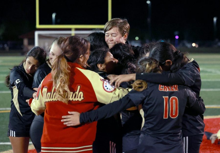 ONE LAST HUG. Coach Gretchen Kloes hugs the seniors from the varsity team after their victory against New Caney High School on March 17, 2023. Having so many seniors who contributed to the program for as long as they have, it was a special night for them having their families there celebrating their success.  Because of their leadership and because they wanted to send them out with a positive positive note and theyre the first team to play six a soccer here at Caney Creek and that comes with pressure. And that comes with expectations and Kloes thought they handled themselves really well, Weve actually never have such a good game, it was 1-1 until the very end and then managed to score with three minutes left to take the win and when you have that kind of emotional game, youre emotional because of that, Kloes said. She experienced something new after the game from any other year, After a game they all kind of came together and wanted to like each person talk and say something about like, were going to miss this and were going to and that hasnt happened before and I think they really understand like what it means to be a team and what it means to be a family and so it was it was very emotional for everybody. There were lots of tears. 