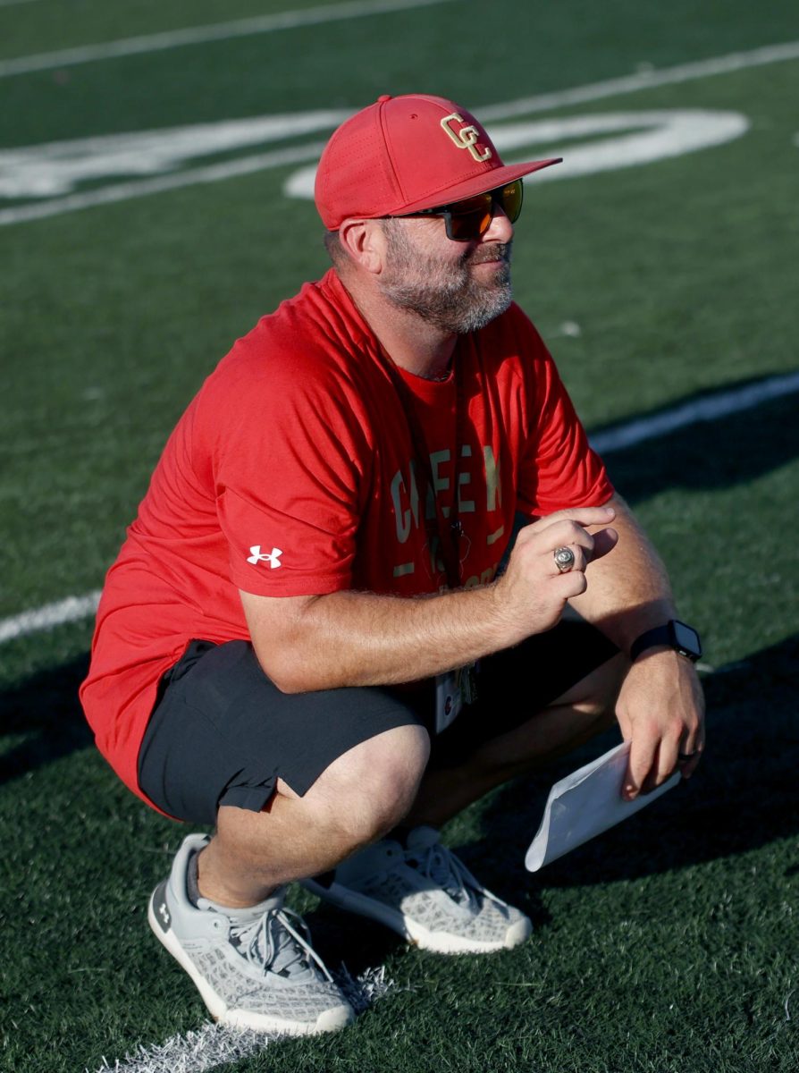 “THIS CLOSE”. Football coach Jared Morris crouches down and shows a symbol during the freshmen gold game against Cleveland on Sept. 21, 2023. Morris had shown that the team had almost won the game. With a few seconds left on the clock, Caney Creek was three steps away from the endzone when the timer hit zero. 
