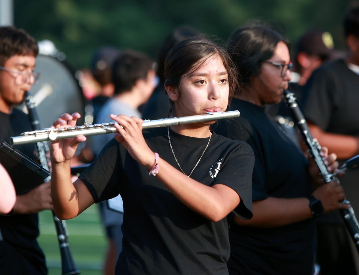 PLAY IN HEAT. Senior Joseline Valadez plays the flute while performing with the band on Thursday, Sept. 14, 2023. Band performed multiple songs, along with “land of a thousand dances” by Chris Kenner, arranged by Paul Martha.