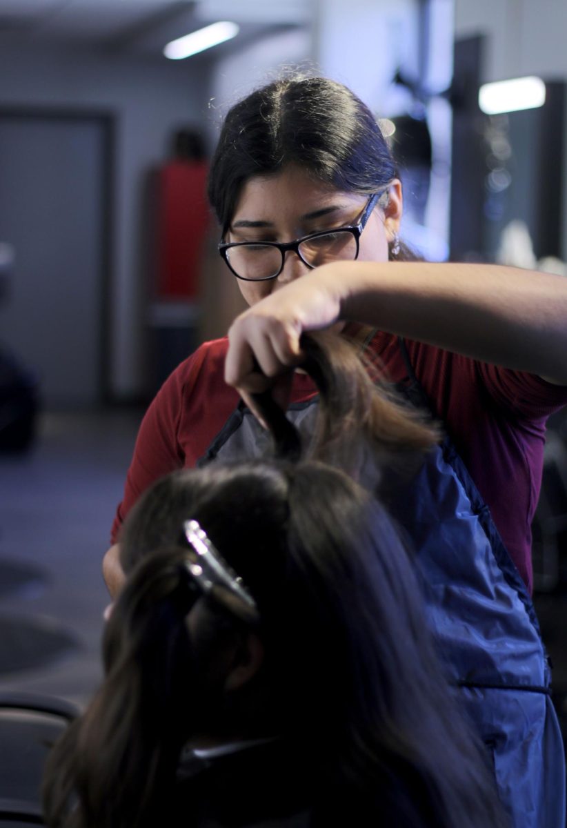 SNIP IT. Senior Anette De Los Santos sections off hair for cosmetology weekly trim on Thursday, Nov. 2, 2023. Students are exposed to practices to help them prepare for Skills USA and for experience in cutting aspect of cosmetology. 