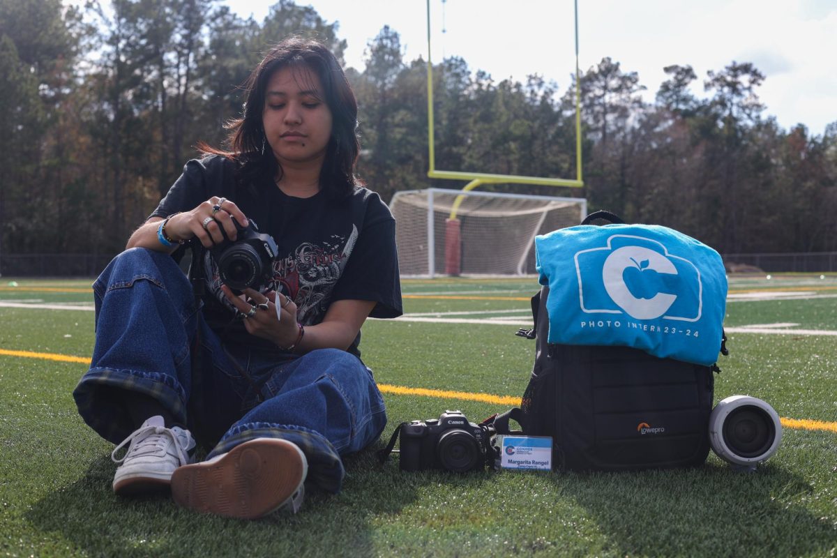 A FALL BACK. Senior Margarita Rangel poses for a picture of her with CISD sport photography inter-ship equipment on Feb. 1, 2024. Rangel found an outlet through photography helping her grow a passion toward the art. In attempt to grow as a photographer she pursued an internship given to students in CISD.