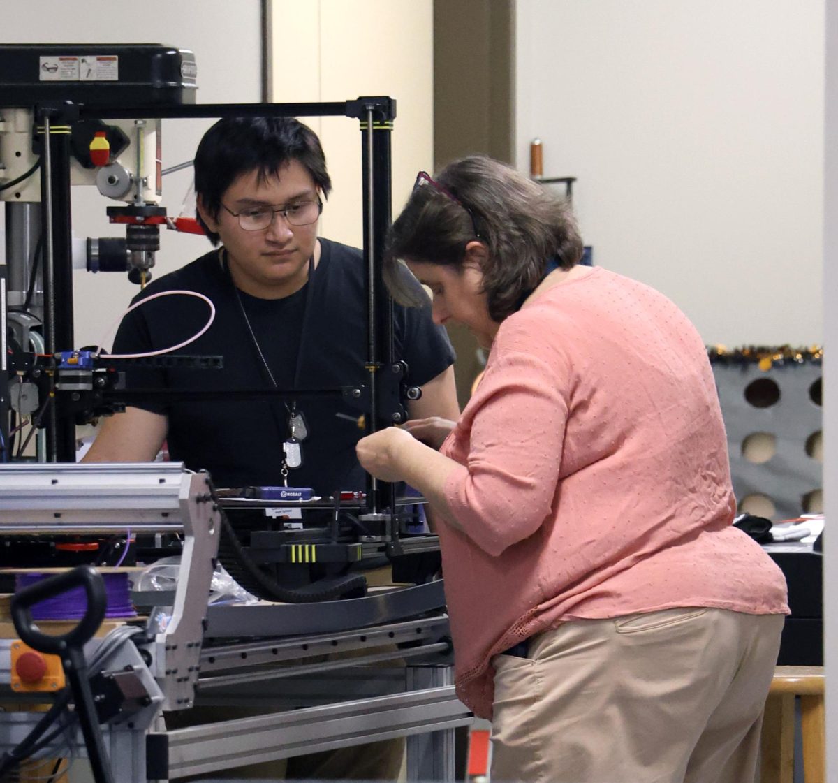 MULTITASKING. Robotics sponsor Irene Macartney looks at the robotics 3D printer Thursday, Feb. 1, 2024. Macartney helped the team by checking on the progress of a part needed to add on a robot.