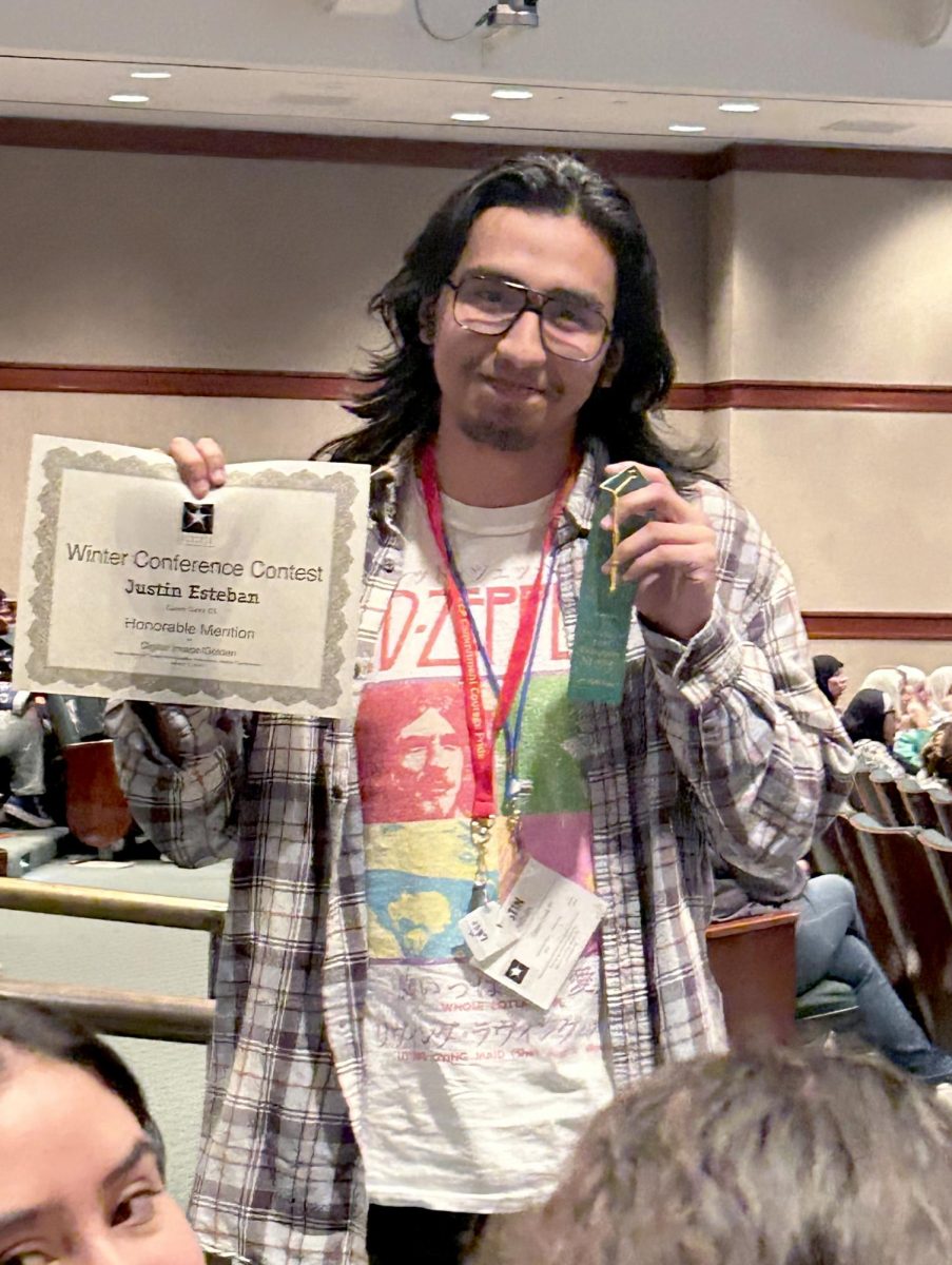 Senior Justin Esteban poses with his Honorable Mention certificate on March 1, 2024 at Austin. Esteban competed in the ATPI winter conference submitting his digital image  with the theme of golden.