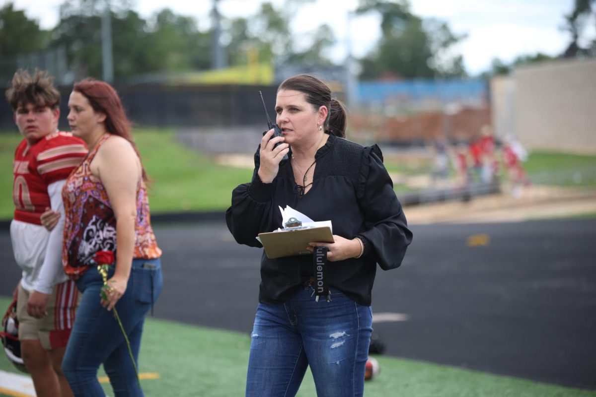 ON IT. Coach Janel Jackson is talking on her radio getting the seniors organized for the senior football game on Sept. 6, 2024. 
