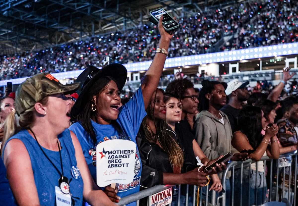 MOTHERS OF HOUSTON. Kamala Harris rally audience members cheer from the general admission rails holding a “Mothers against Greg Abbott” sign in NRG Stadium on Oct. 25. Abbot is the Governor of Texas, who had a hand in abortion laws. The phrase was meant to parallel the infamous Donald Trump slogan, “Make America Great Again” by using the same acronym 