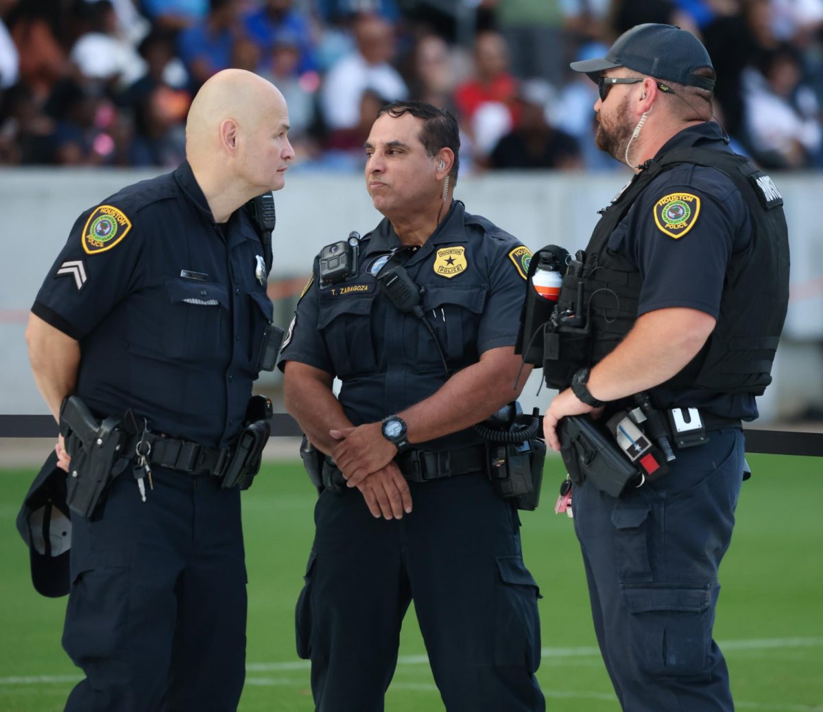 GUARD. Three police officers converse together in the general admission section at the Houston Kamala Harris rally held in NRG Stadium on Oct. 25. The rally had police guarding every entrance of the building, along with secret service hidden in the stands of the stadium.