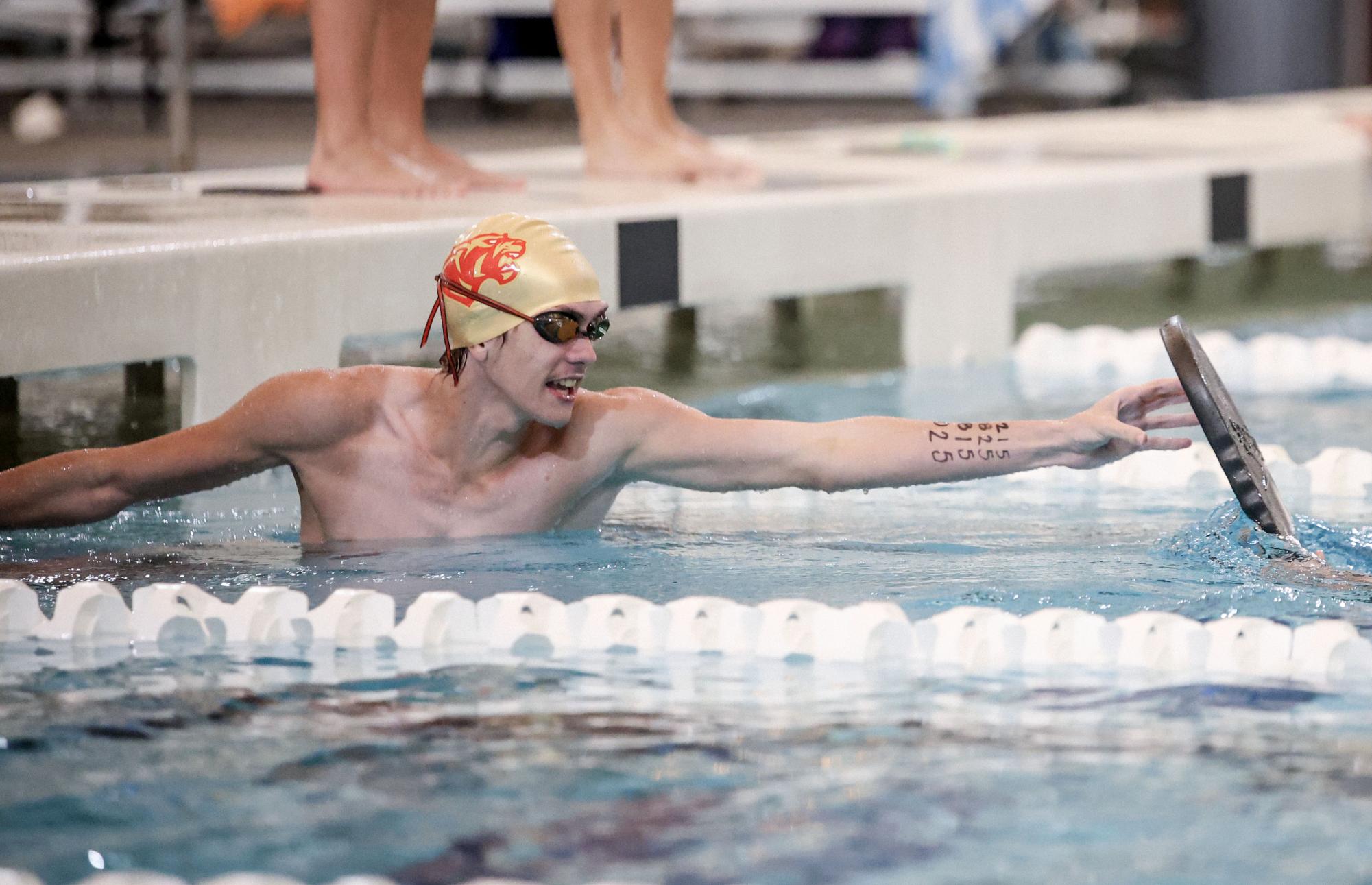 ANTICIPATION. Senior Christopher Hargraves leans off the wall of the pool at the swim meet against College Park on Oct. 29. Hargreaves was participating in a special Halloween themed relay that required him to start from the wall.