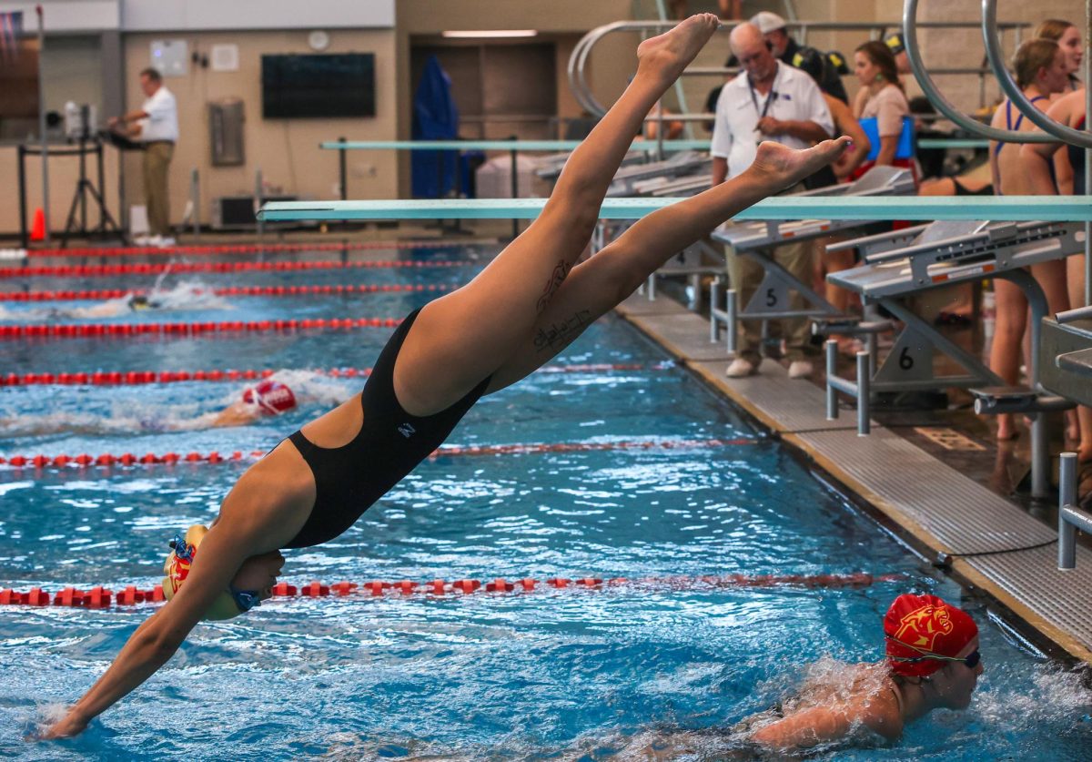 SPEED. Junior Abigail De La Garza diving at the New Caney Invitational on December 6th, 2024. Abigail was later seen swimming freestyle.