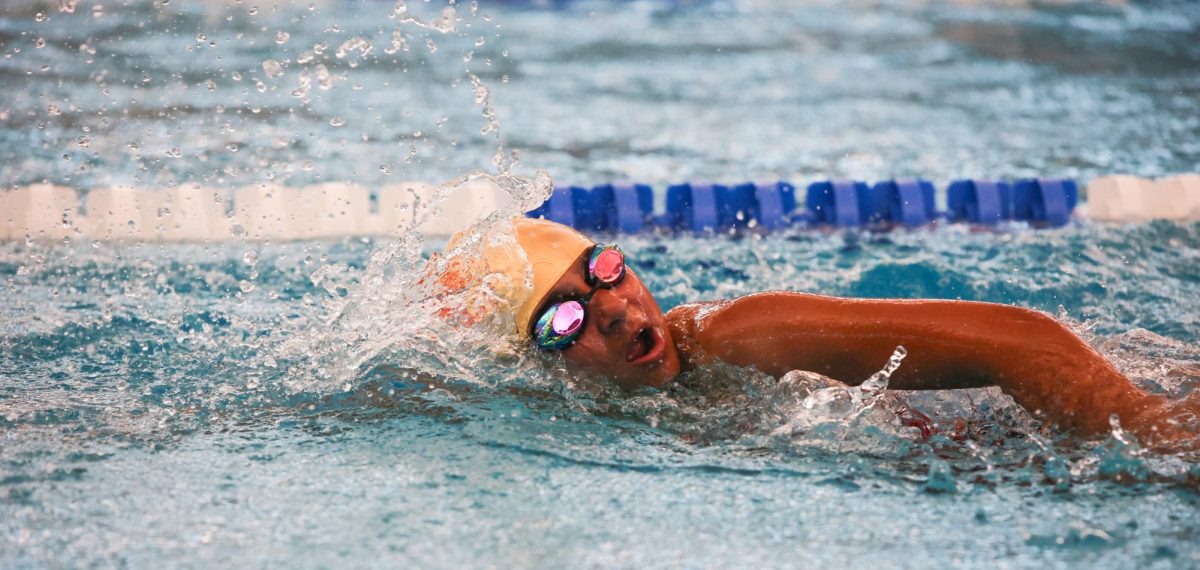 BREATH. Freshman Raelyn Baier swimming freestyle at the New Caney Invitational on December 6th, 2024.