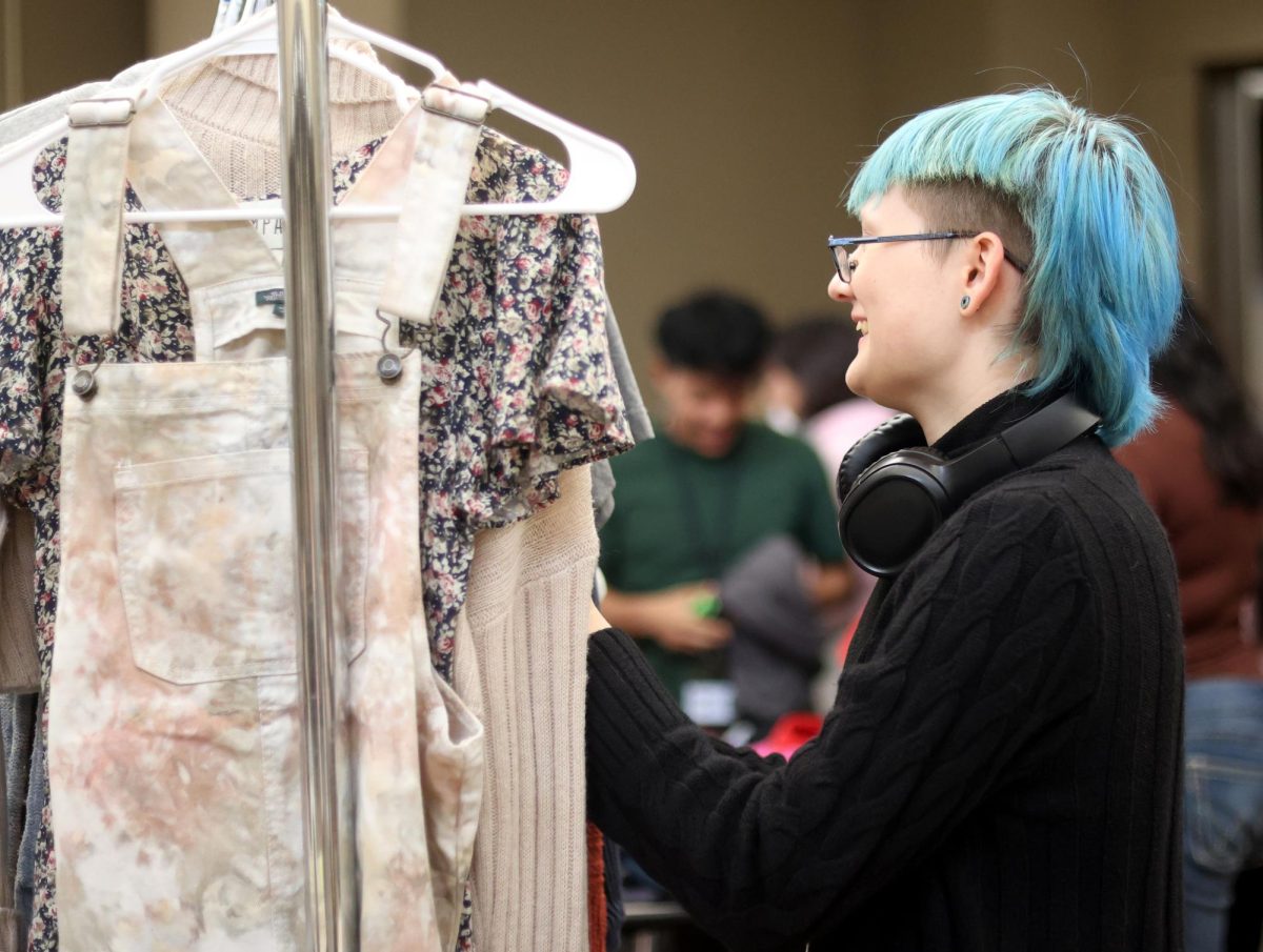 HMMM… Junior Mason Rezzoffi looks through a rack of donated clothing at the winter thrift store held by STUCO on Dec. 12.