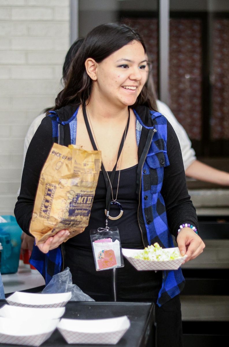 SERVICE. Senior Amberleigh Alvarez hands out free trays of microwave popcorn at the winter thrift store held by STUCO on Dec. 12.