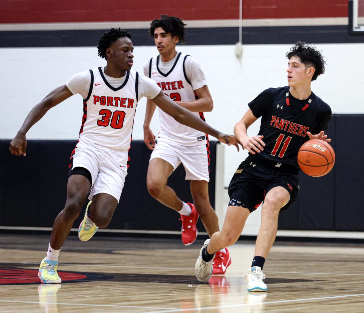 CENTER LINE.Senior Derek Darkenwald holds back the ball in the center of the court at Porter High School on Nov. 26, 2024. The Panthers traveled to Porter highschool over the break to face off the Porter Spartans as they prepare for the 2024-2025 