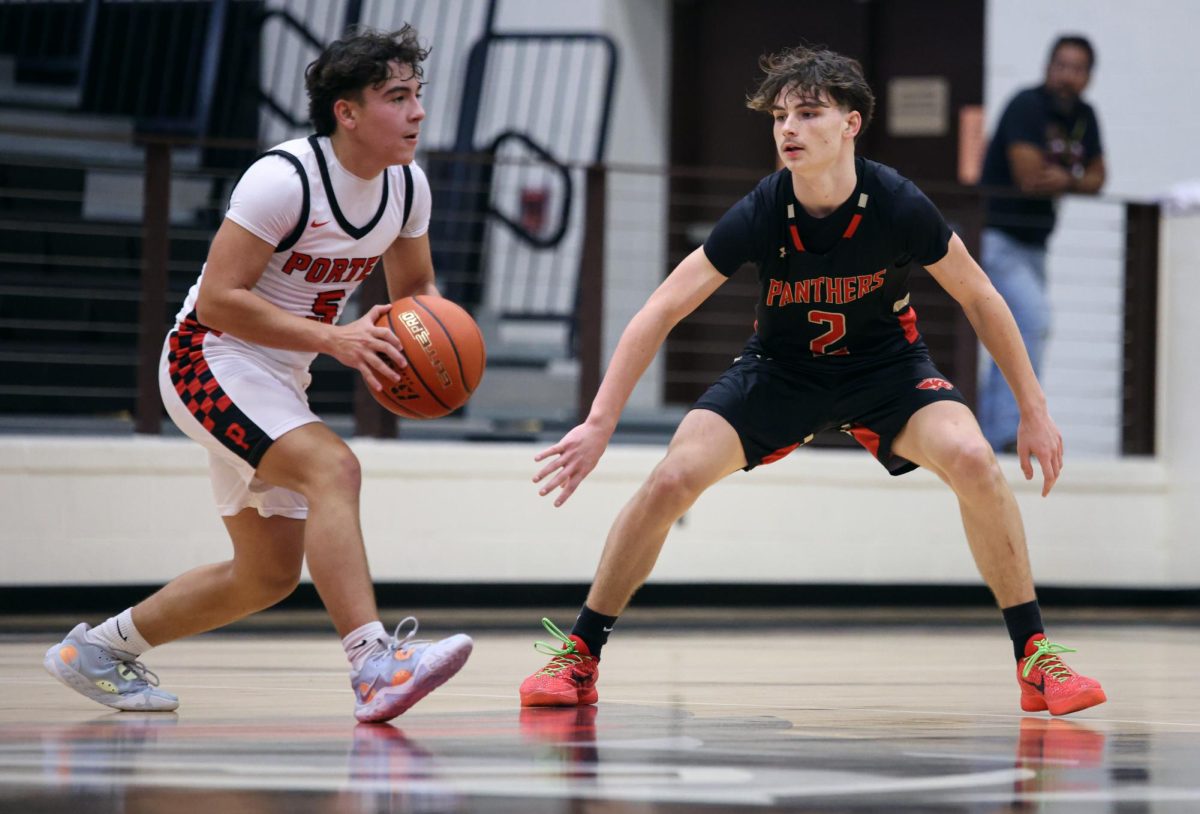 MAN TO MAN. Sophomore Rayden Peroni keps hawk eyes on his man while playing defense at Porter High School on Nov. 26, 2024. Peroni makes his appearance on the varsity squad as a sophomore as key players.peroni made a couple at the end of the season last year showing he is a key player for the panthers.“ Our goal is to make the playoffs this year,” Peroni said.