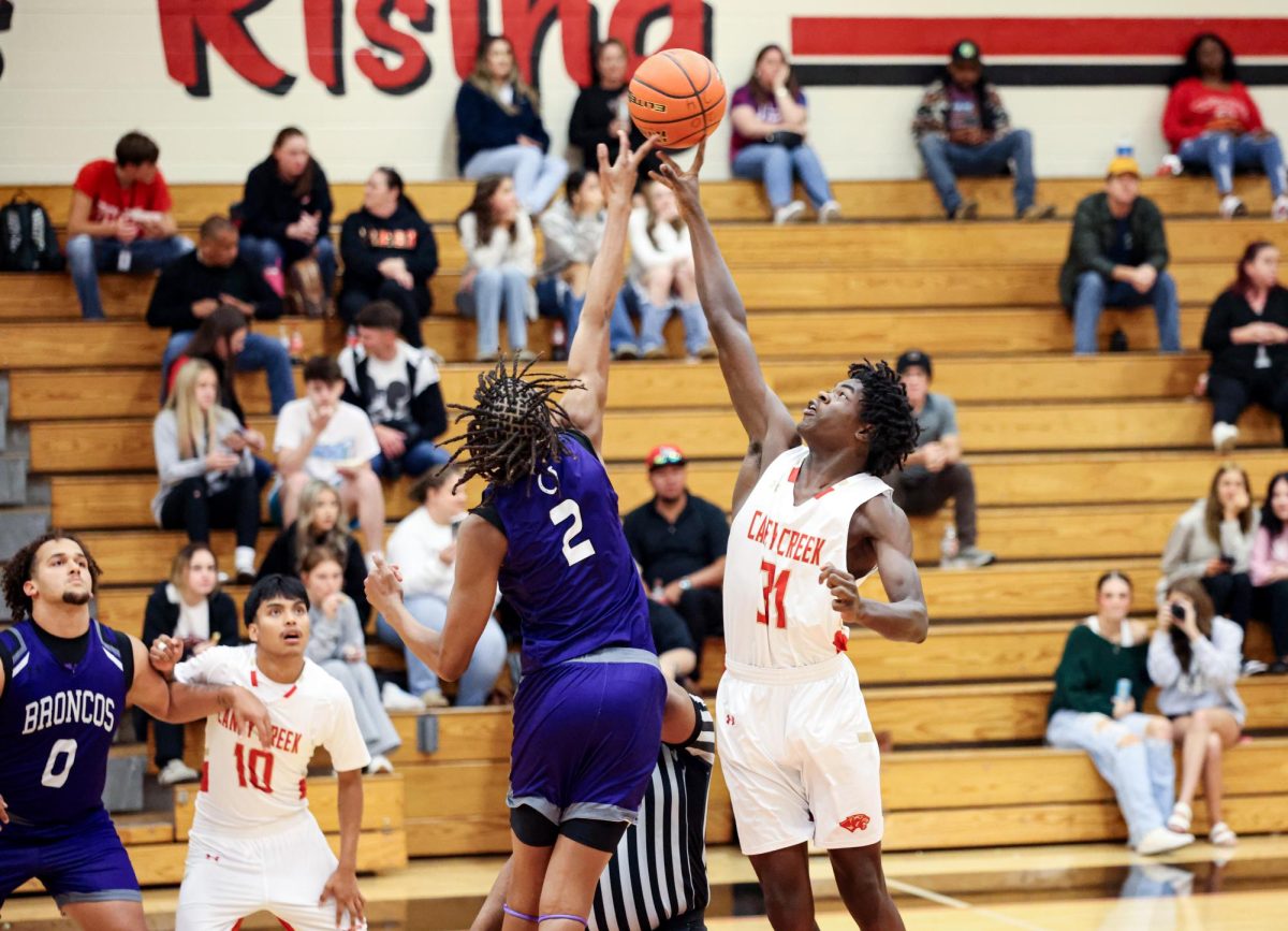 JUMP BALL. Junior Frank Harris competes with the opposing team player in the jump ball at the beginning of the game in Friday's game against Dayton High School on Nov. 15, 2024.