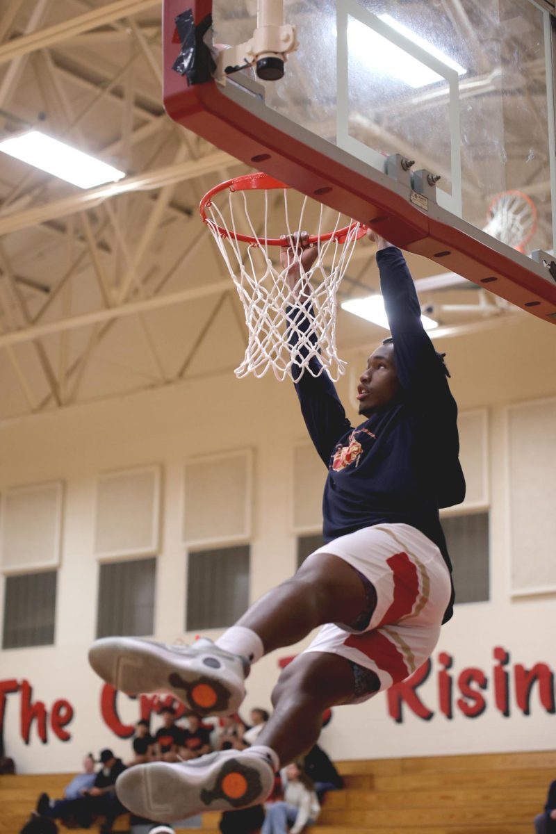 READY. Senior Jeremiah Thomas is dunking in the lay-up lines at the game against The Woodlands on Tuesday, Dec. 3, 2024. 