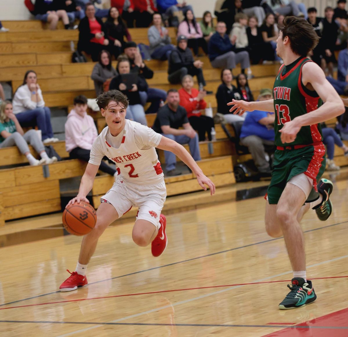 GETTING BY. Sophomore Rayden Peroni drives the ball into the basket and tries to score against The Woodlands on Tuesday, Nov. 3, 2024. 